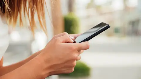 Mujer sosteniendo un dispositivo móvil con las manos Mujer sosteniendo un dispositivo móvil con las manos