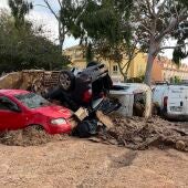 Coches apilados e inservibles tras el paso de la DANA por Alfafar