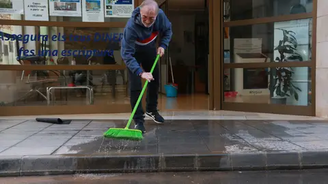 Un veí d'Alcanar retirant aigua del seu local. Un veí d'Alcanar retirant aigua del seu local.