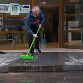 Un veí d'Alcanar retirant aigua del seu local.