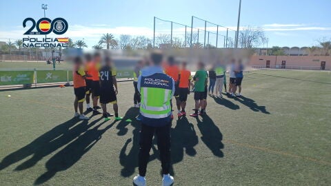 Un agente de la Polic&iacute;a Nacional con algunos de los j&oacute;venes captados por la red.