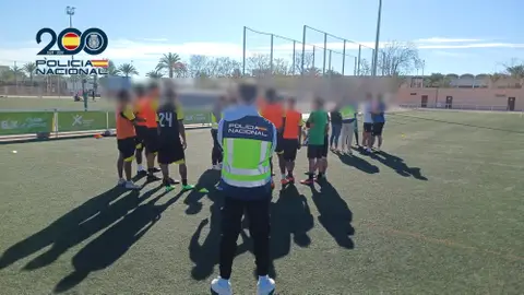 Un agente de la Policía Nacional con algunos de los jóvenes captados por la red. Un agente de la Policía Nacional con algunos de los jóvenes captados por la red.