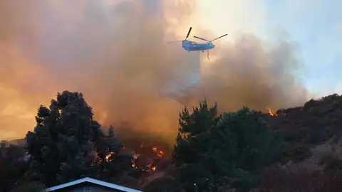 Un helicóptero arroja agua sobre una casa durante el incendio forestal de Palisades en Los Ángeles, California (EE.UU.). Un helicóptero arroja agua sobre una casa durante el incendio forestal de Palisades en Los Ángeles, California (EE.UU.). / EFE/ALLISON DINNER