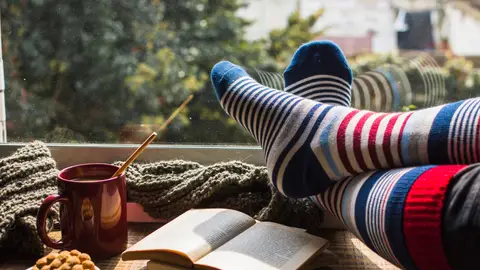Imagen de recurso: pies cubiertos con calcetines de invierno apoyados sobre una mesa Imagen de recurso: pies cubiertos con calcetines de invierno apoyados sobre una mesa