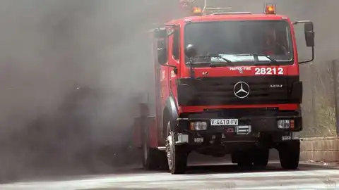 Un camión de bomberos sale de la intensa humareda. Un camión de bomberos sale de la intensa humareda.