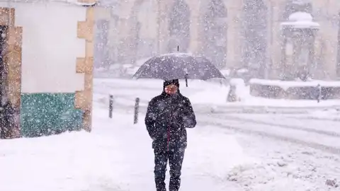 Una persona camina por una calle cubierta de nieve.