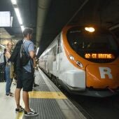 Imagen de archivo de viajeros esperan en el andén de la estación barcelonesa de Sants a subir a un tren de Rodalies.
