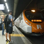 Imagen de archivo de viajeros esperan en el andén de la estación barcelonesa de Sants a subir a un tren de Rodalies. Imagen de archivo de viajeros esperan en el andén de la estación barcelonesa de Sants a subir a un tren de Rodalies.