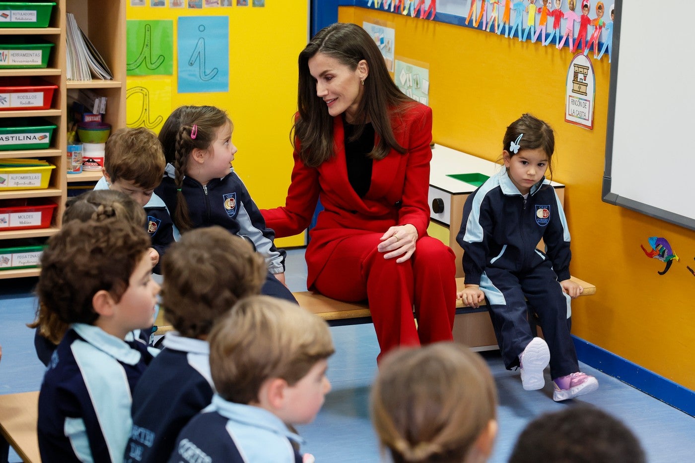 La cercanía de la reina Letizia al leer un cuento a unos niños sentada en el suelo e interactuando con ellos La cercanía de la reina Letizia al leer un cuento a unos niños sentada en el suelo e interactuando con ellos