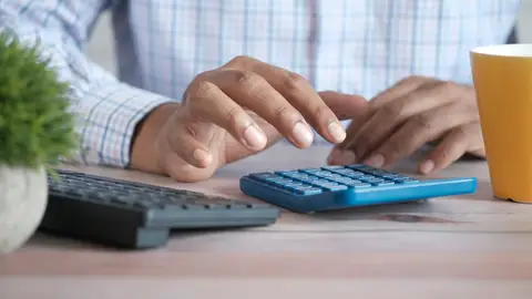 Imagen de archivo de una persona que utiliza su calculadora. Imagen de archivo de una persona que utiliza su calculadora.