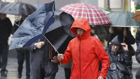 Un hombre trata de protegerse de la lluvia y el viento este jueves en Bilbao. Un hombre trata de protegerse de la lluvia y el viento este jueves en Bilbao.