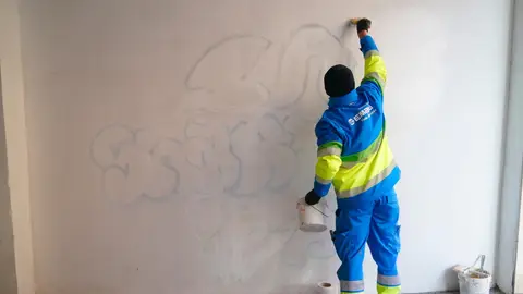 Imagen de archivo de un trabajador eliminando un grafiti. Imagen de archivo de un trabajador eliminando un grafiti.