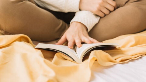 Imagen de archivo: mujer leyendo un libro en la cama 