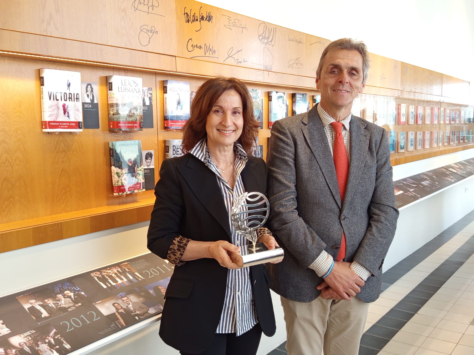 Paloma Sánchez Garnica coloca su ejemplar firmado de ‘Victoria’ en la galería de los Premios Planeta de El Pedroso Paloma Sánchez Garnica coloca su ejemplar firmado de ‘Victoria’ en la galería de los Premios Planeta de El Pedroso