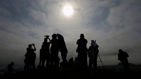 Varias personas mirando un eclipse solar desde las montañas de Bernal Heights en San Francisco en agosto de 2017