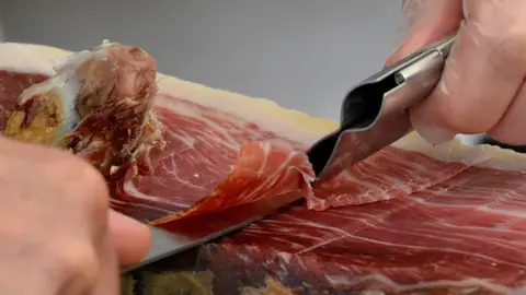 No metas jamón ni queso en tu maleta: la nueva prohibición del Reino Unido que afecta a turistas europeos Corte de jamón ibérico