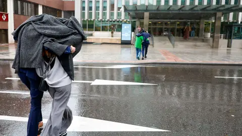 Varias personas se protegen de la lluvia caída este lunes en Madrid. Un frente atlántico hace que el inicio de mayo sea frío y lluvioso