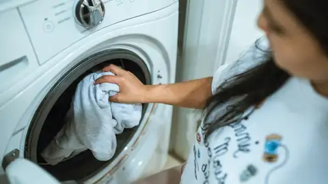 Una persona poniendo la lavadora Una persona poniendo la lavadora