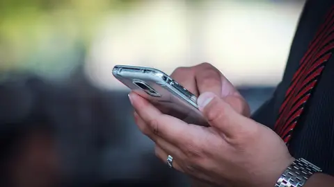 Imagen de archivo de una persona que utiliza su teléfono móvil. Imagen de archivo de una persona que utiliza su teléfono móvil.