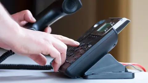 Una persona marca un número de teléfono El número con el que empezarán todas las llamadas spam a partir de ahora: así podrás identificarlas