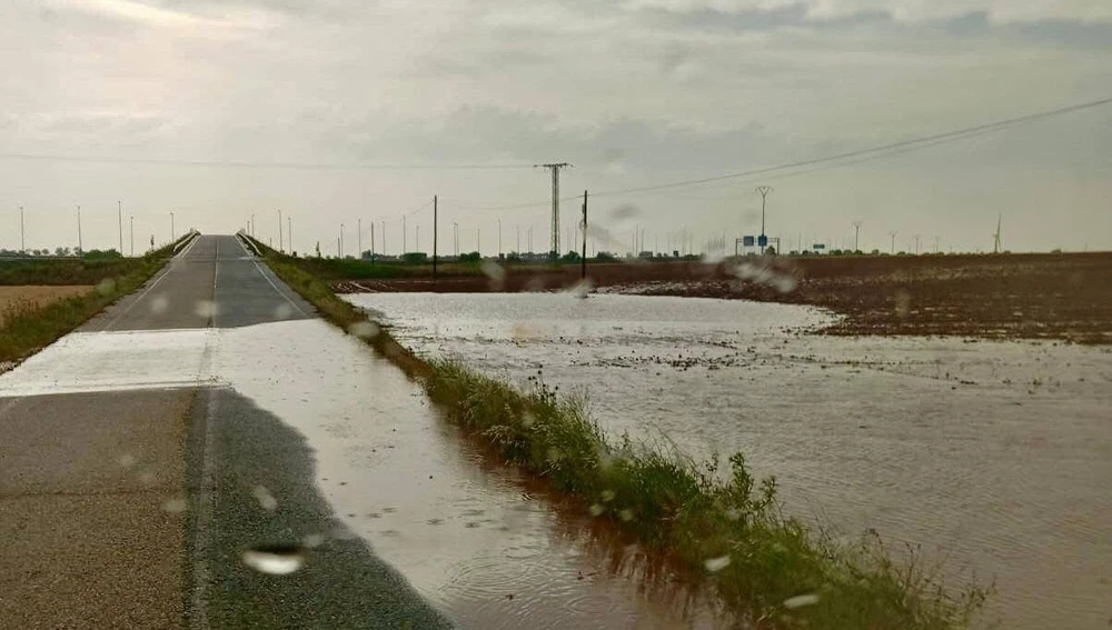 Desbordamiento a su paso por la carretera de la localidad Desbordamiento a su paso por la carretera de la localidad