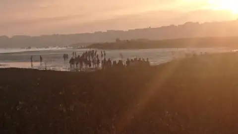 Gente acudiendo a El Puntal de Somo Gente acudiendo a El Puntal de Somo