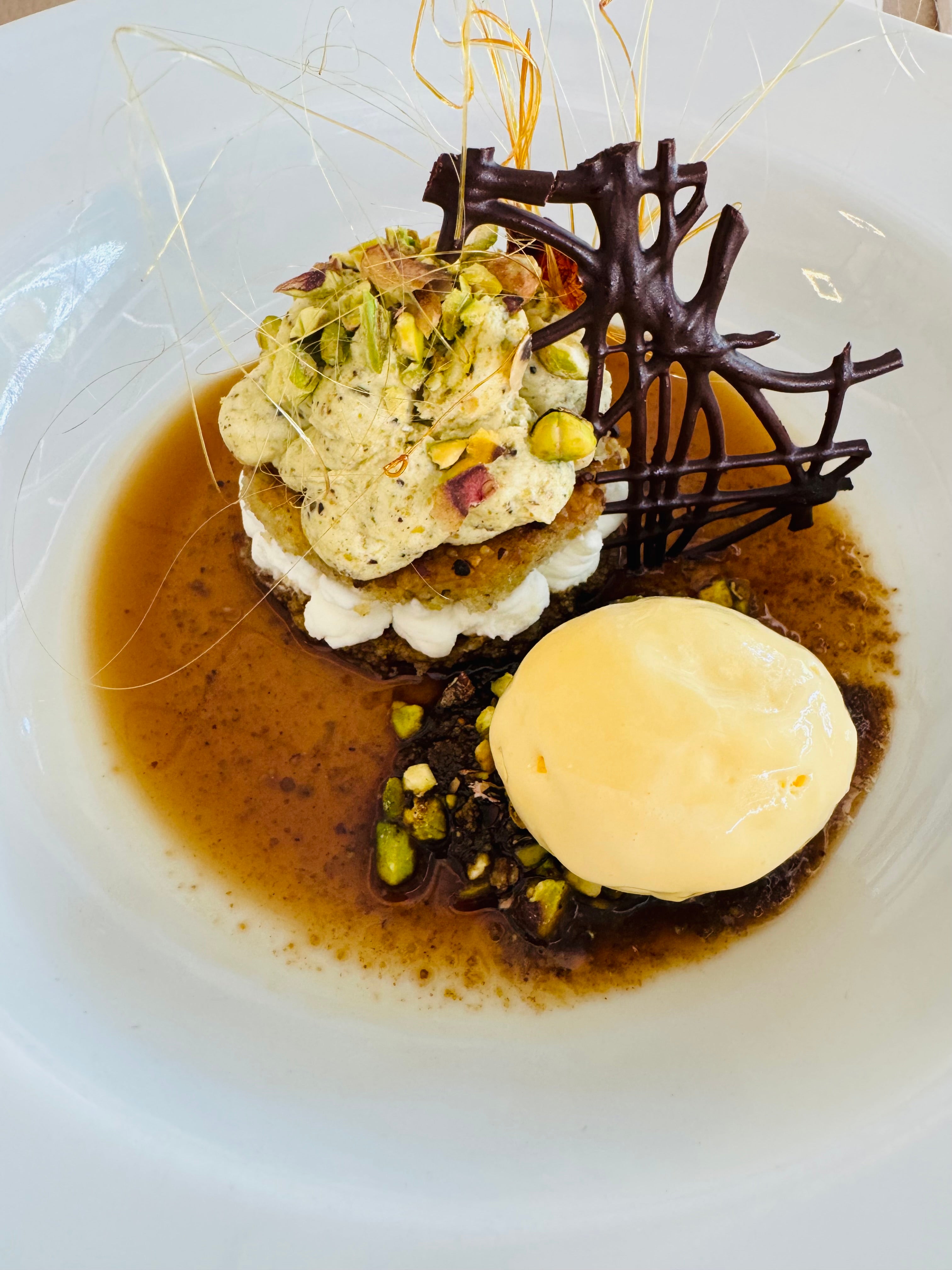 Delicias de pistacho con su mousse, crema de leche merengada, tierra de pistachos, hilos de caramelo con gele de café y helado de licor Delicias de pistacho con su mousse, crema de leche merengada, tierra de pistachos, hilos de caramelo con gele de café y helado de licor