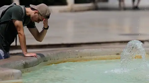 La gente se protege y refresca en el centro de Valencia. La gente se protege y refresca en el centro de Valencia.
