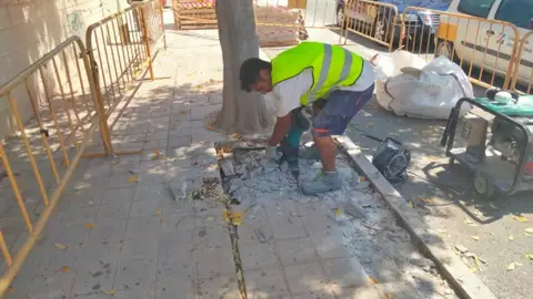 Trabajador renovando el estado de la acera Trabajador renovando el estado de la acera