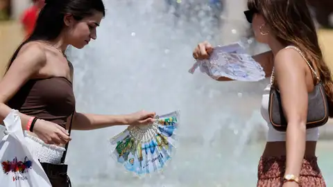 La gente se protege y refresca en una imagen de archivo. La gente se protege y refresca en una imagen de archivo.