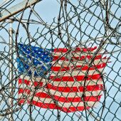 Una bandera dels Estats Units eclipsada per les reixes d'una presó