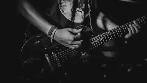 Una persona tocando la guitarra Una persona tocando la guitarra