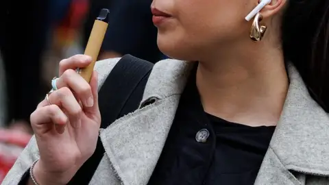 SINGAPUR SE PLANTEA CATALOGAR EL VAPEO COMO DROGA Imagen de archivo de una mujer con un vapeador
