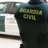 Archivo - Un agente de la Guardia Civil, de espaldas, junto a un vehículo oficial. - GUARDIA CIVIL - Archivo