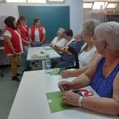 Mujeres mayores en el taller de Cruz Roja con sus voluntarias