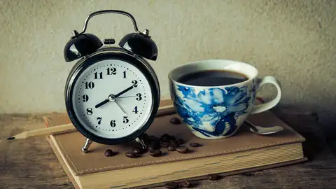 Imagen de un reloj con una taza de café Imagen de un reloj con una taza de café