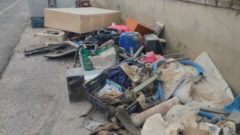 Residuos acumulados junto a un contenedor de basura de Elche.