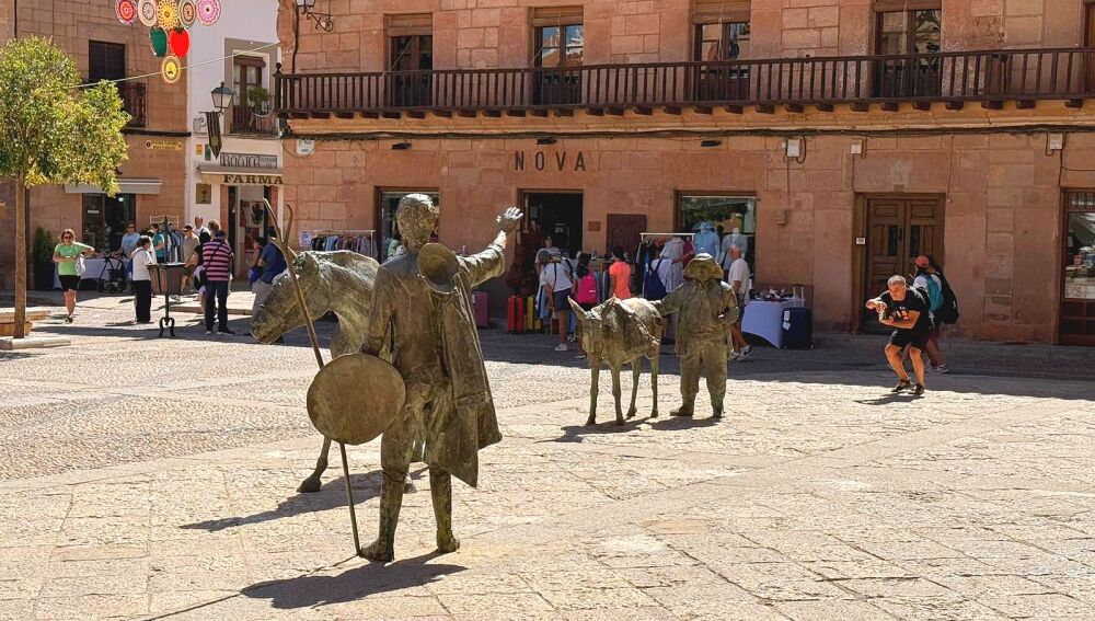 Un ciudadano fotografía a Don Quijote y Sancho Panza en la Plaza Mayor de Villanueva de los Infantes