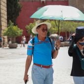 Archivo - Varios turistas se resguardan del sol con sombreros y paraguas para soportar las altas temperaturas en Sevilla. Foto de archivo. - Rocío Ruz - Europa Press - Archivo