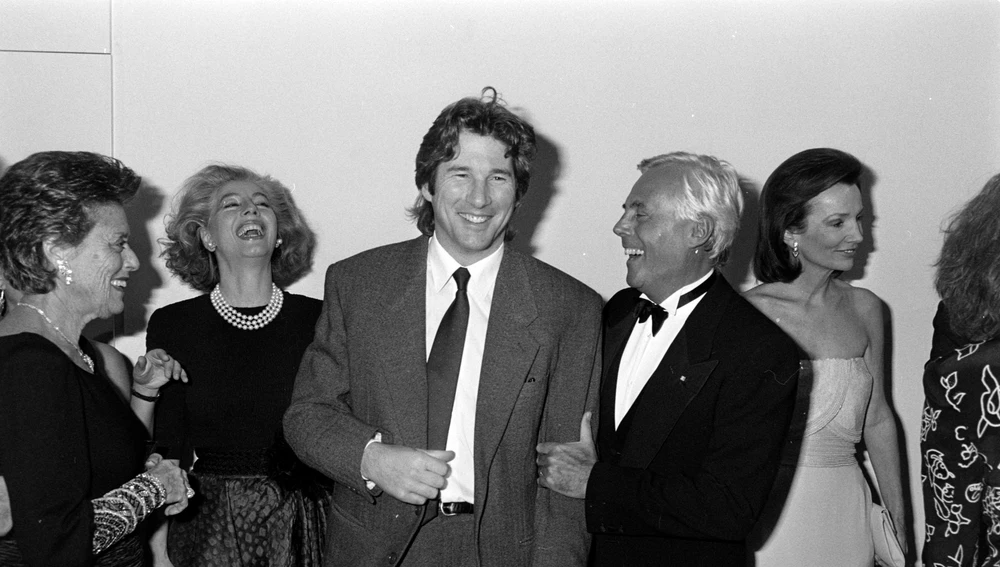 El actor Richard Gere muestra la etiqueta de su traje al diseñador Giorgio Armani, mientras los invitados observan el intercambio con la socialité Lee Radziwill. El actor Richard Gere muestra la etiqueta de su traje al diseñador Giorgio Armani, mientras los invitados observan el intercambio con la socialité Lee Radziwill.