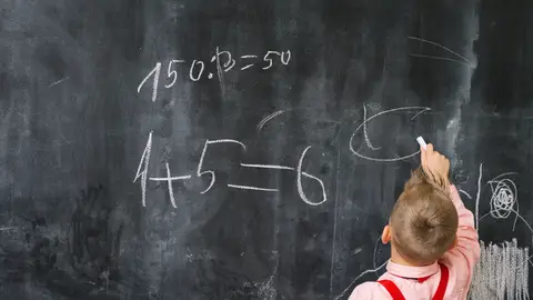 Ninño escribiendo en una pizarra Ninño escribiendo en una pizarra