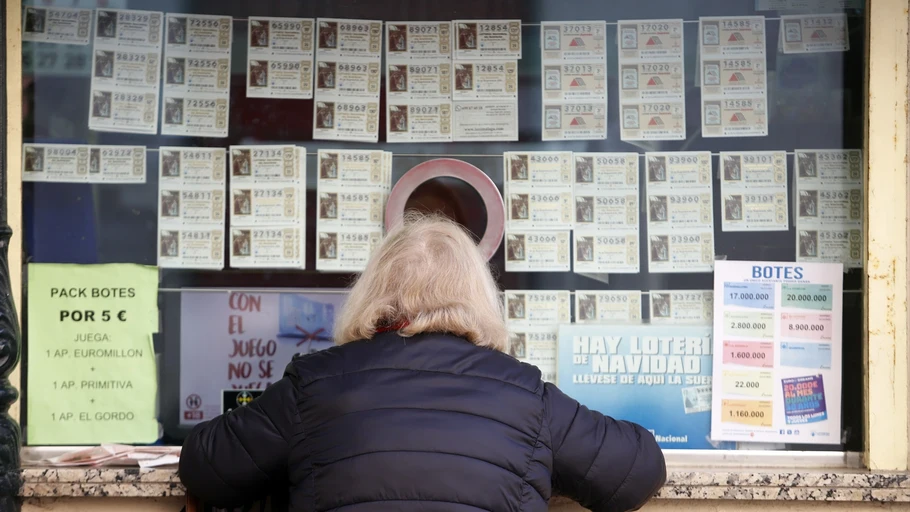 Una mujer comprando décimos de la lotería de Navidad