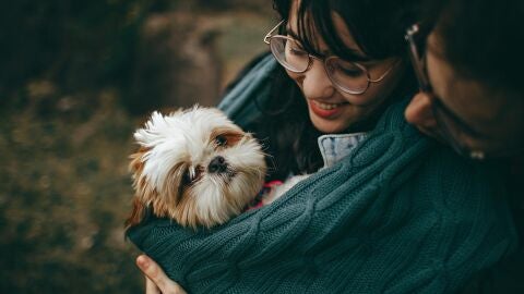 Una pareja con su perro en brazos