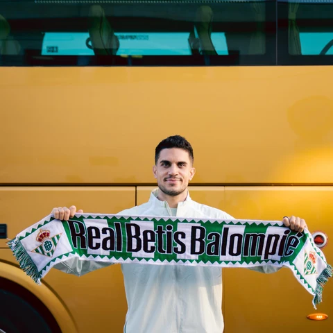 Marc Bartra posa con una bufanda del Betis antes del vuelo de la expedición verdiblanca a Lieja.
