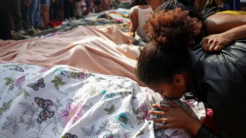 Una persona de luto besa un cuerpo cubierto tras una operación policial mortal contra el narcotráfico en la favela do Penha, en Río de Janeiro, Brasil. Una persona de luto besa un cuerpo cubierto tras una operación policial mortal contra el narcotráfico en la favela do Penha, en Río de Janeiro, Brasil.