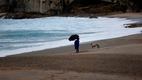 Una mujer observaba el mar este martes desde la playa del Orzán, en A Coruña. Una mujer observaba el mar este martes desde la playa del Orzán, en A Coruña.