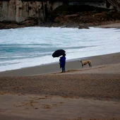 Una mujer observaba el mar este martes desde la playa del Orzán, en A Coruña. Una mujer observaba el mar este martes desde la playa del Orzán, en A Coruña.