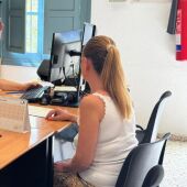 Una funcionaria del Ayuntamiento de Elche atiene a una ciudadana en una OMAC.