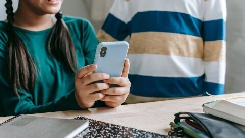 Ni&ntilde;a con un tel&eacute;fono m&oacute;vil.