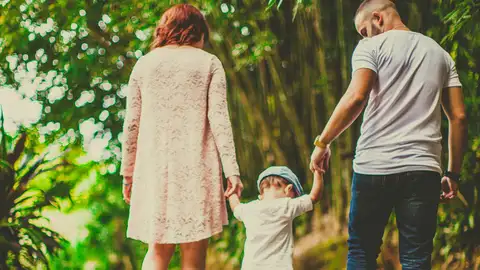 Una pareja con su hijo paseando por el parque Una pareja con su hijo paseando por el parque